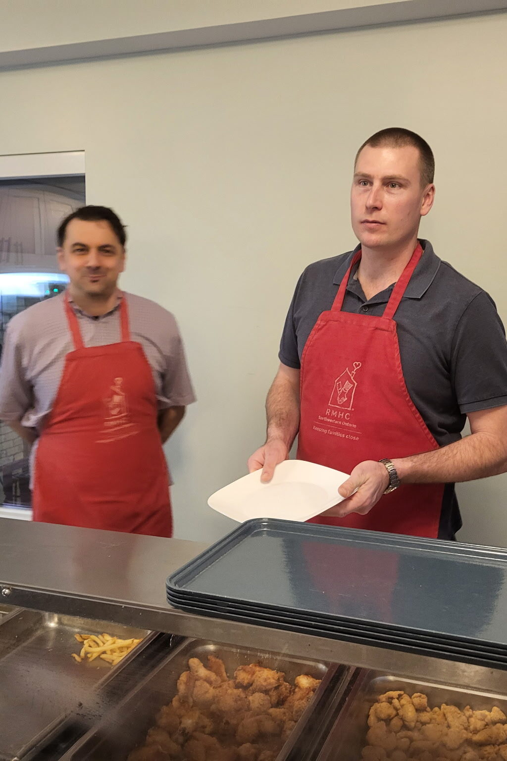 Two members of the Tuscan 195 serving dinner at Ronald McDonald House