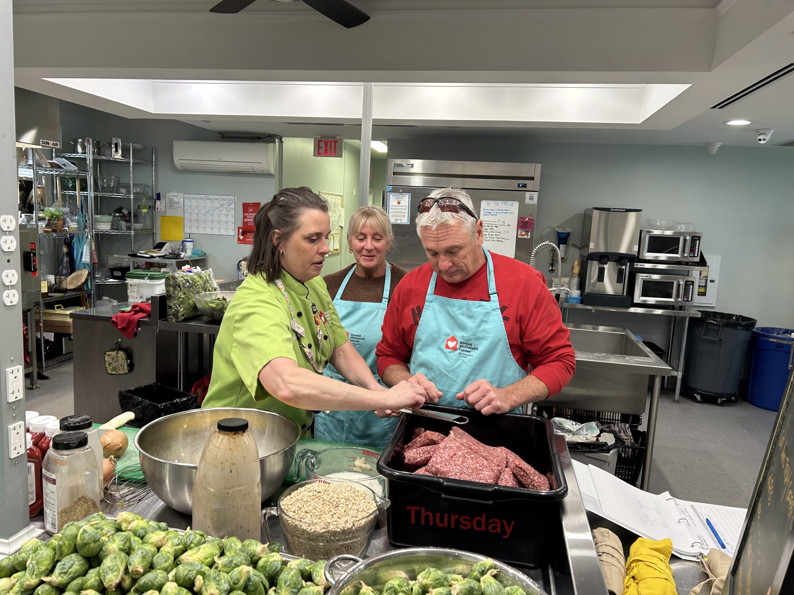 Tuscan Lodge No. 195 volunteers preparing food together in a kitchen at Ronald McDonald House Southwestern Ontario.